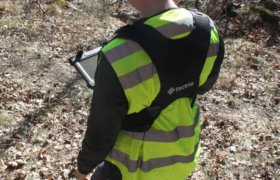 Person bakifrån med tactile bärsele och tactile logo